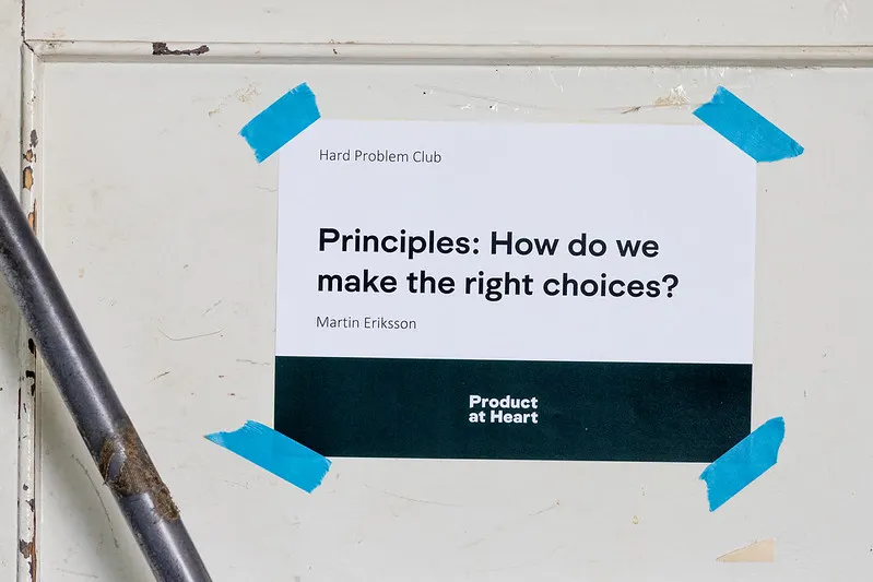 A sign taped to a door: "Hard Problem Club. Principles: How do we make the right choices? Martin Eriksson. Product at Heart."